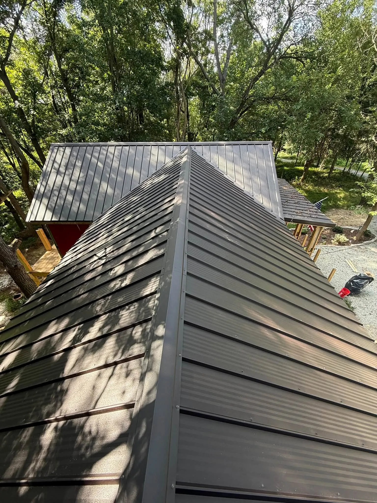 The roof from above, with a gable section running into the main roof among the trees