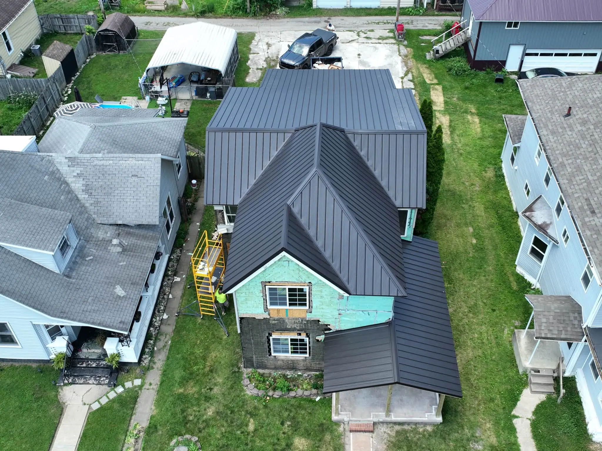 Overhead view of the finished metal roof, including the new porch roof at the front of the house