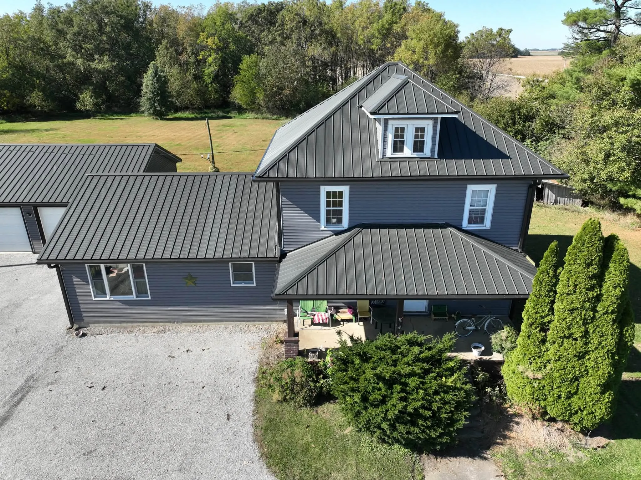 Closer view of the front, with the dormer on the main roof and the metal running down over the front porch