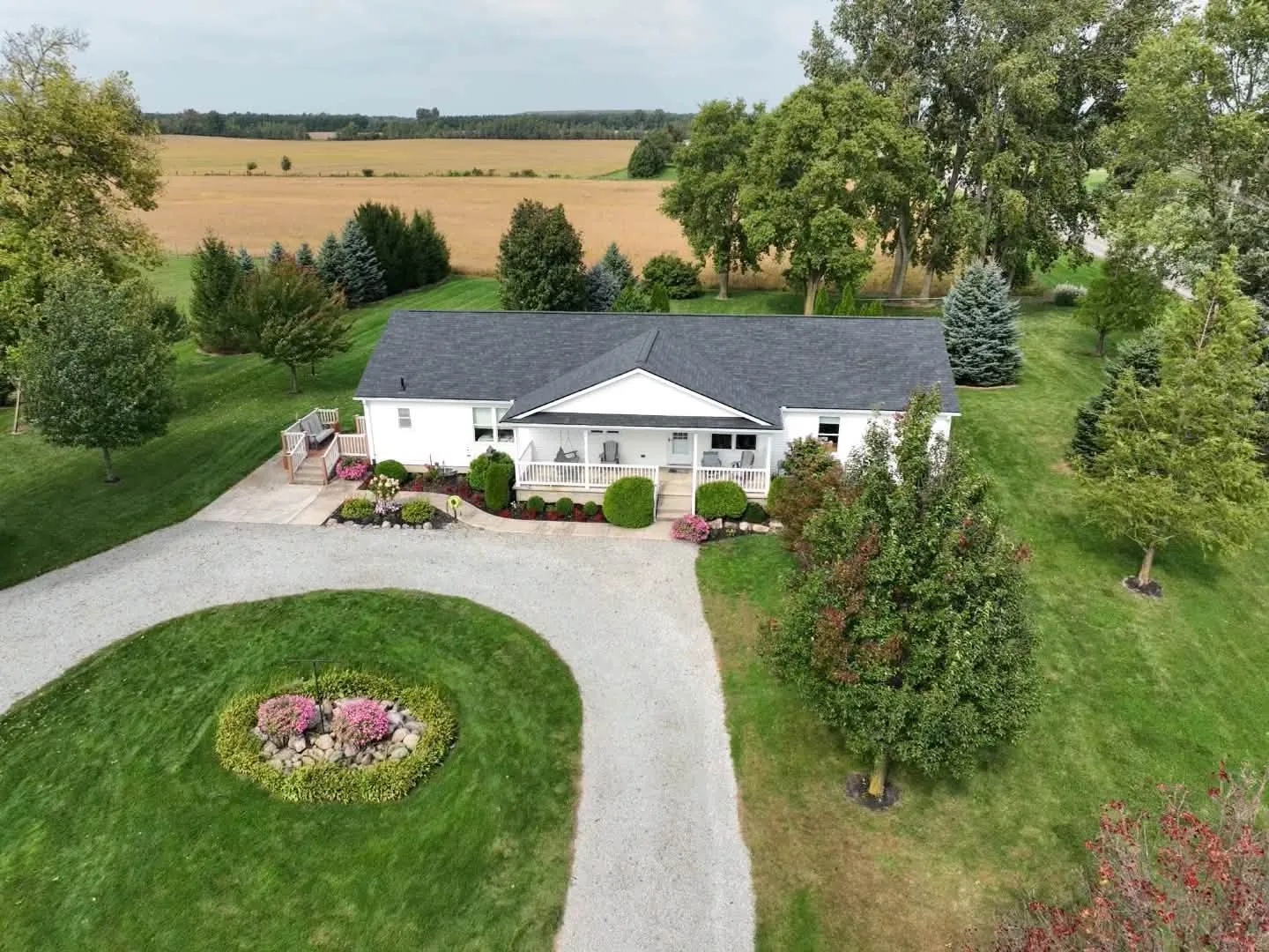 Higher view of the house and the circle drive, with farm fields stretching out behind