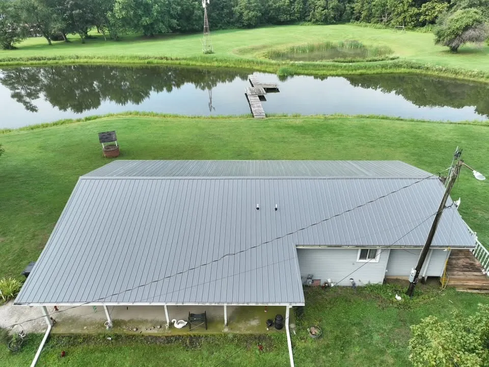 The roof from above the porch, with the pond and its dock behind the house