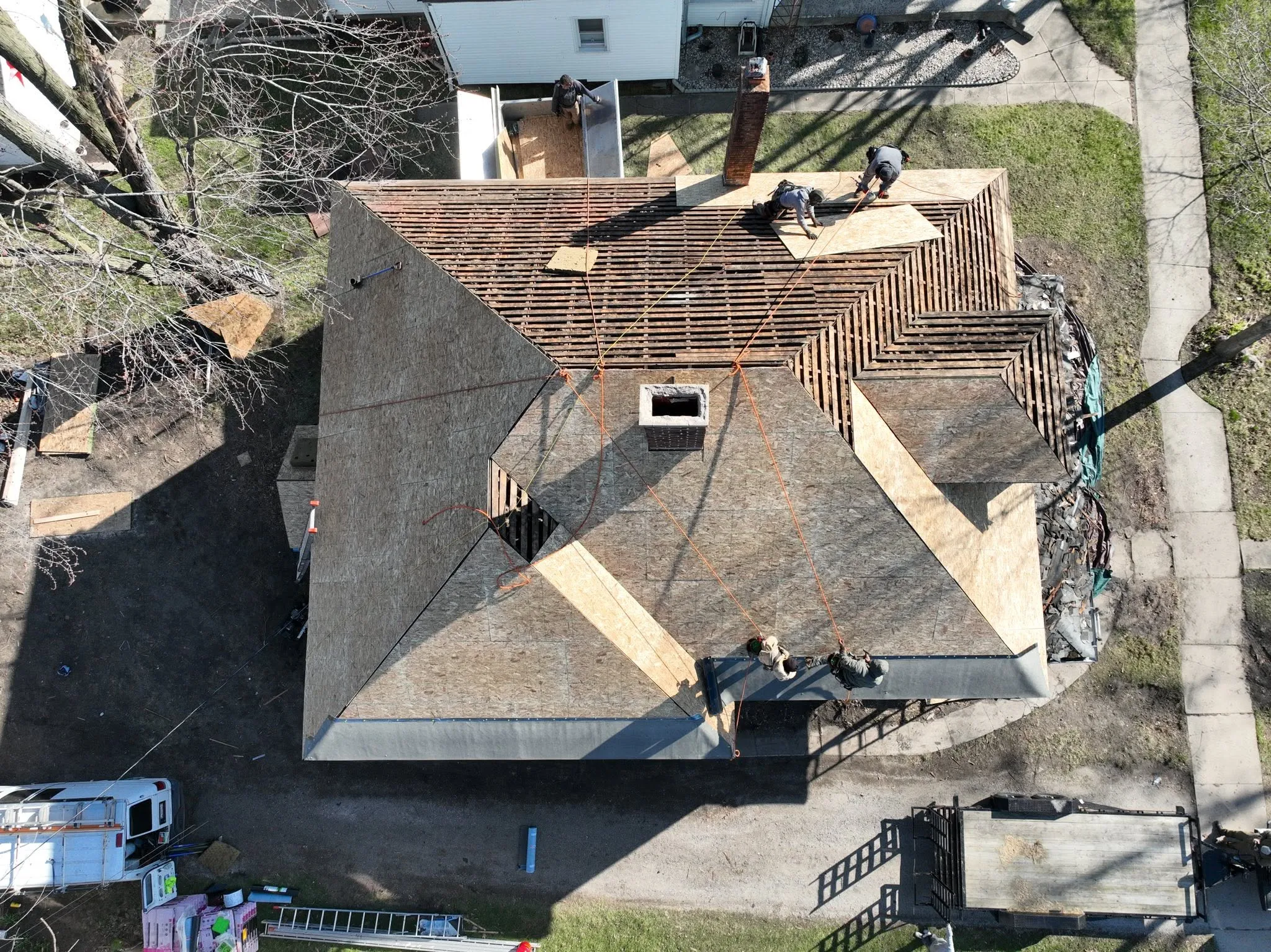 The same roof later in the job, sheeted in new decking with the crew working across it