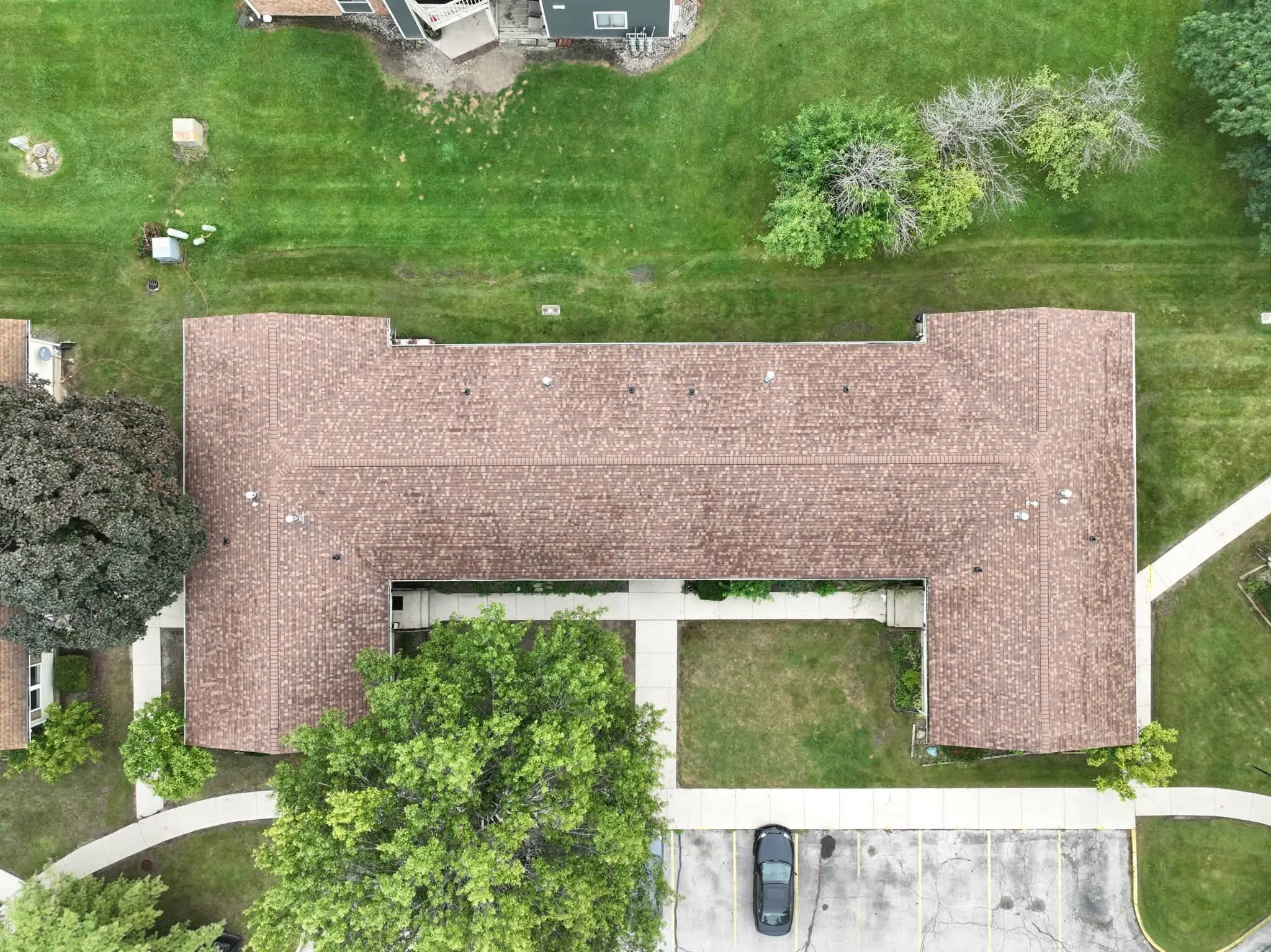 Straight-down view of the U-shaped building with its new roof and the courtyard lawn in the middle