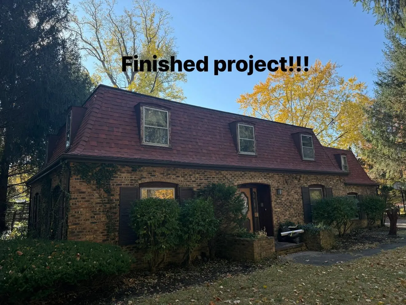 The finished brick house with its new deep red shingle roof and dormers, labelled Finished project