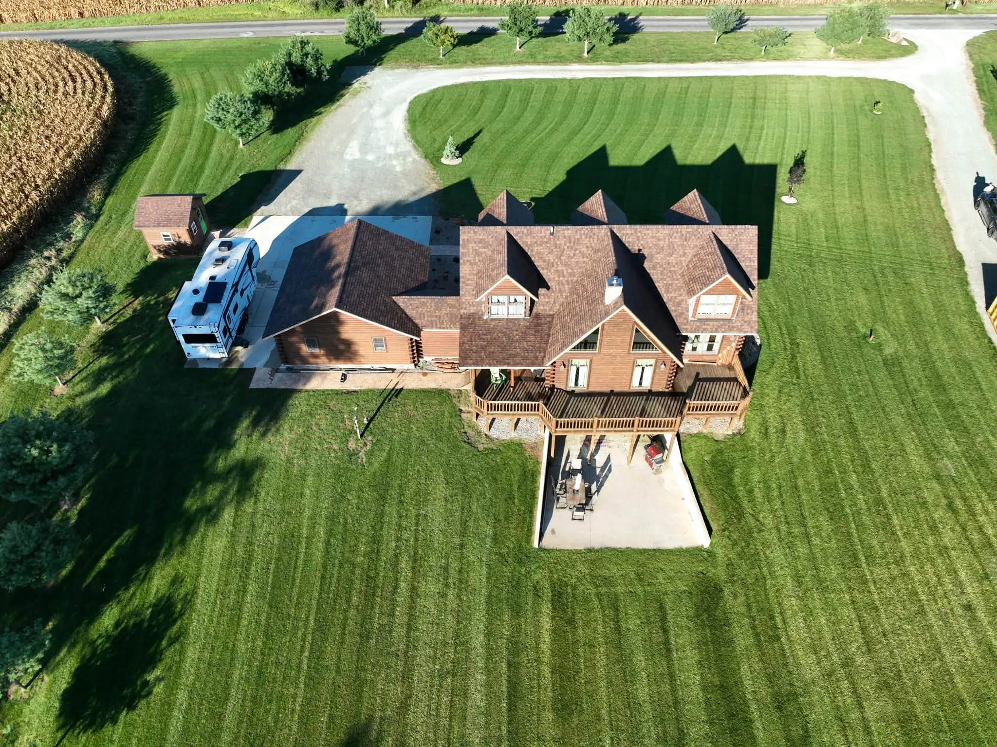 Wide view of the property from behind, with the house, the garage wing, and the circle drive