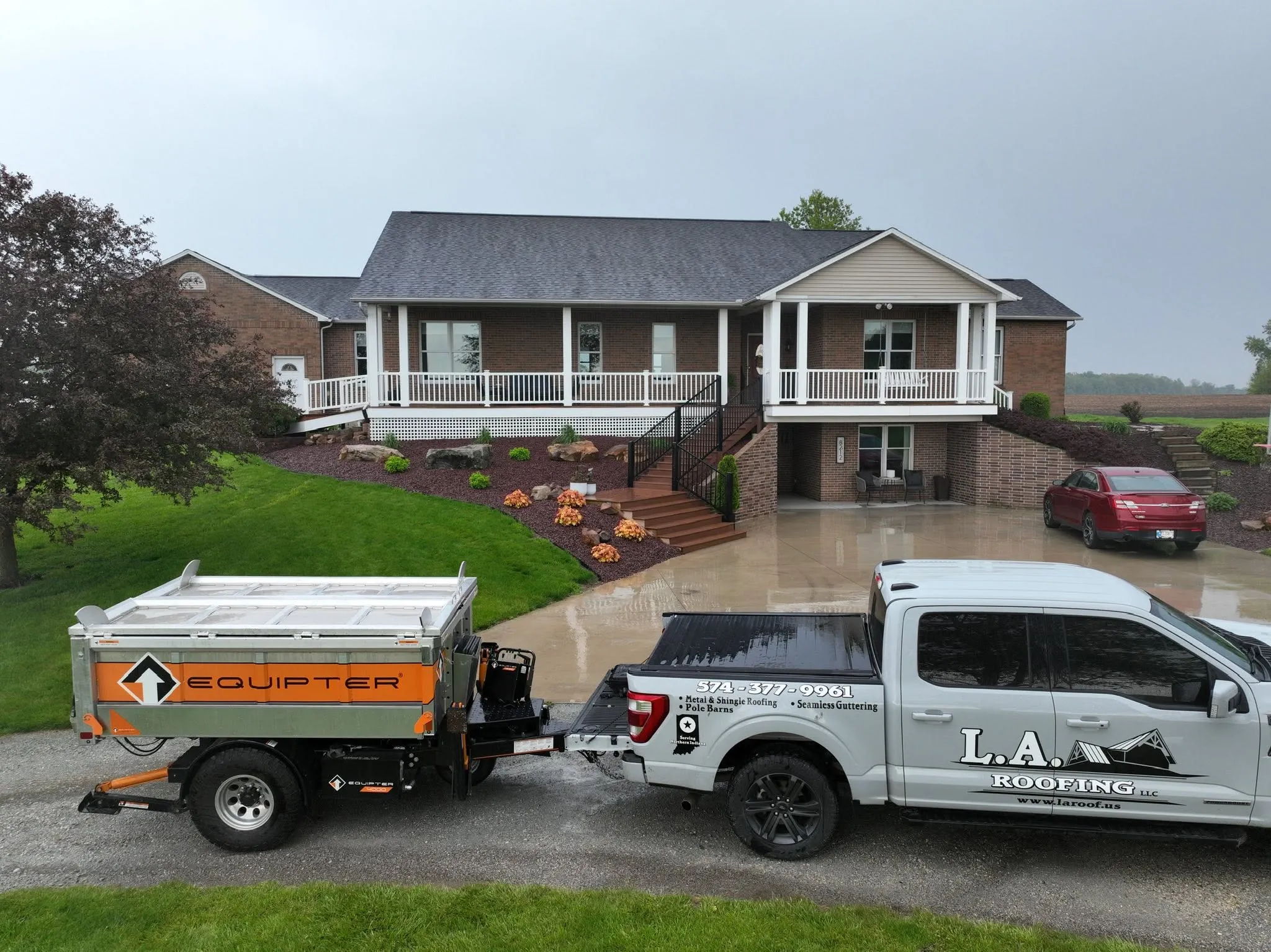 The finished house from the driveway with the L.A. Roofing truck and dump trailer parked in front
