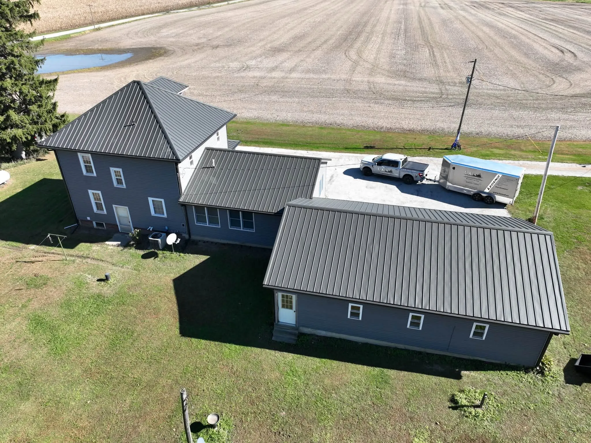 The back of the house and garage from above, with a plowed field behind
