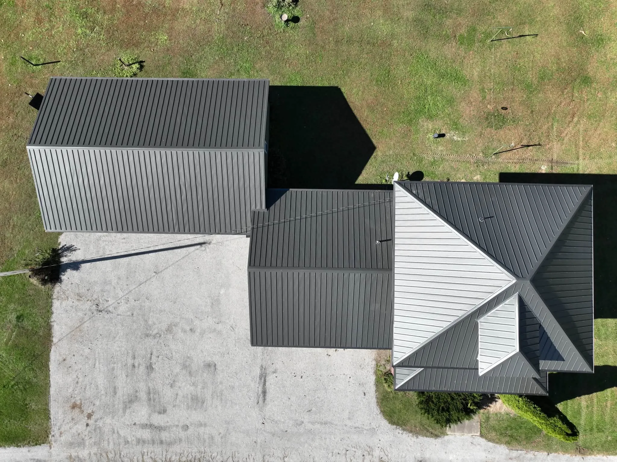 Straight-down view of the metal roofs, with the hips and dormer on the main house