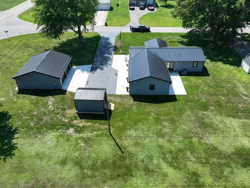 The back of the house and the detached garage from above, with the road and neighboring homes behind