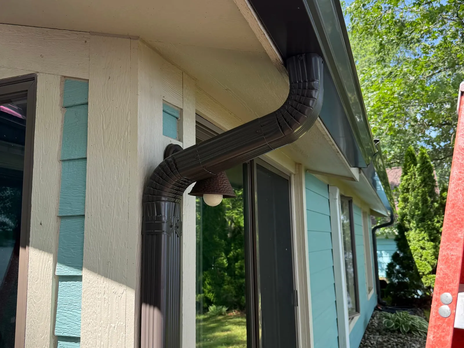 Dark downspout running down the corner of a home
