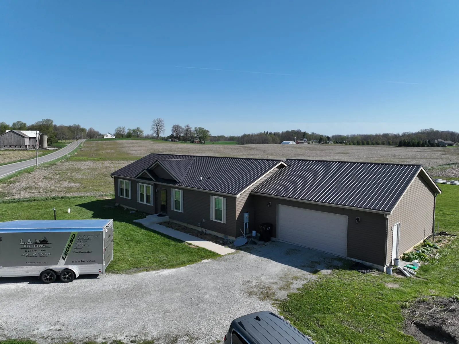 Contemporary home with a dark standing-seam metal roof and attached garage