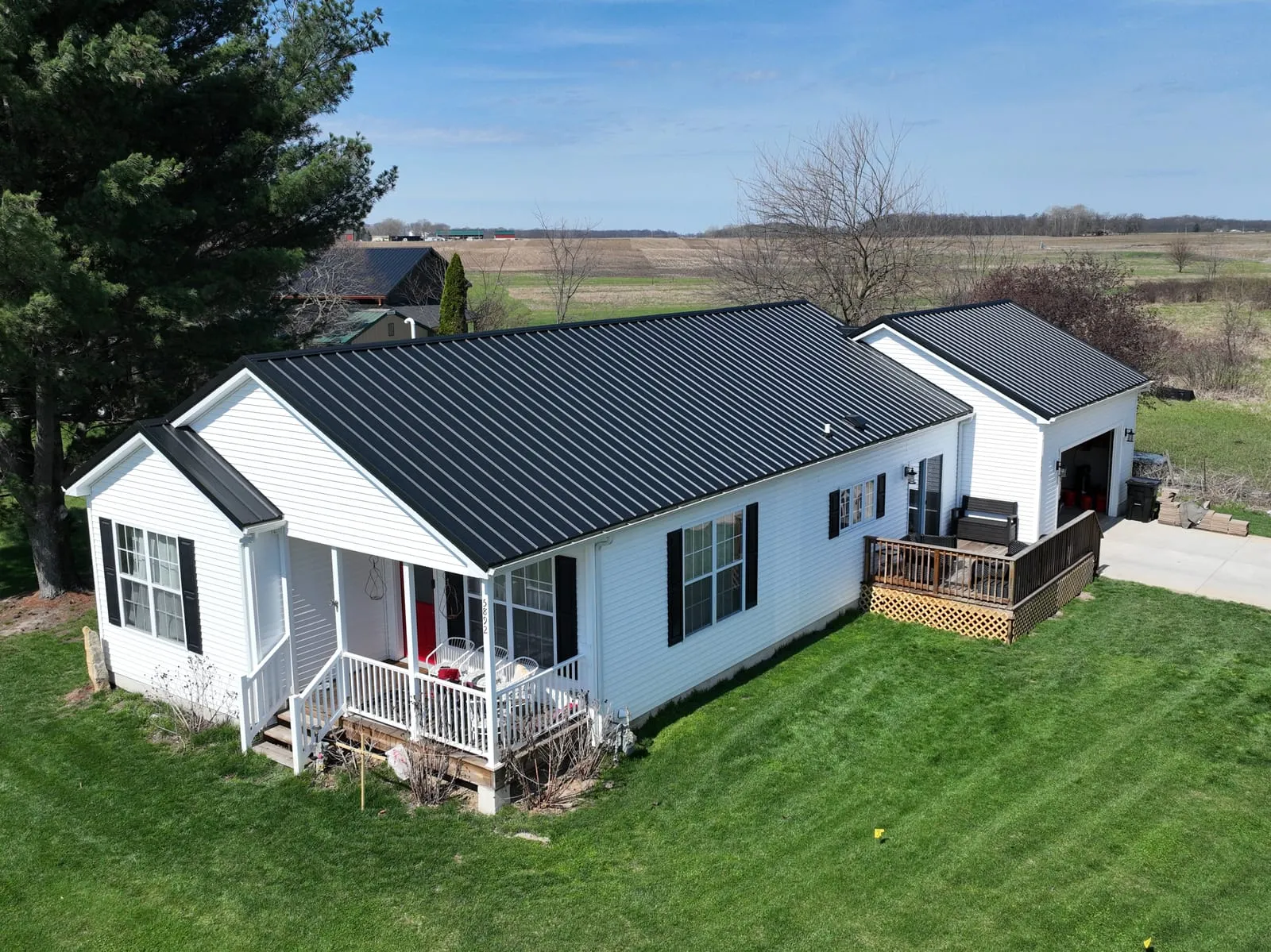 Ranch home with a dark charcoal metal roof against a blue sky